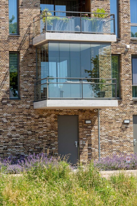 Modern balkon met glazen wanden en een transparante balustrade voor beschutting en uitzicht.